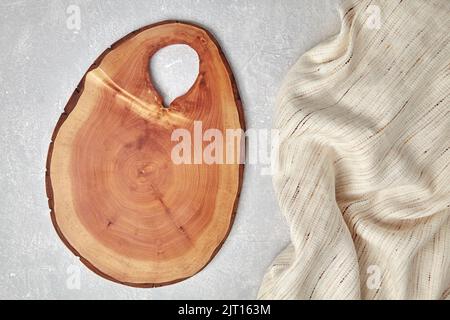 Cutting board and coasters on a gray concrete table with a kitchen towel. Food display template Stock Photo