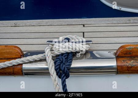 Close up of ropes and a mooring cleat on a classic sailing yacht. Stock Photo