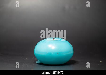 A blue candle on isolated black background Stock Photo