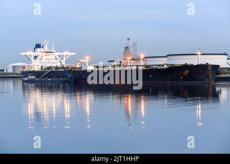 Crude oil supertanker being unloaded in a oil terminal at twilight Stock Photo