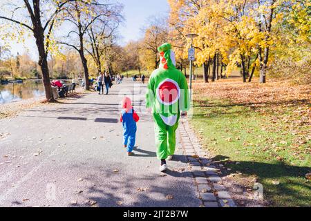 Costume walk in a public park. It was in autumn. The leaves had turned yellow and orange. This was the Westpark in central Munich in Germany. Stock Photo