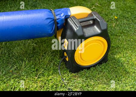 Electric trampoline pump. Air generator. Turbine on rubber casing. Details of amusement park. Stock Photo