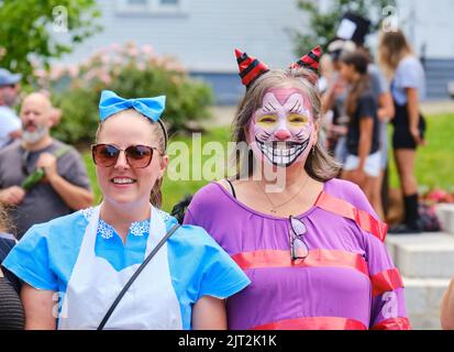 Halifax, Nova Scotia, Canada. August 27th, 2022. Alice and the Cheshire Cat still smiling as their team sets off through the streets of Halifax in search of the next clue in the Alice in Wonderland adventure. For one day only, the streets of Halifax are transformed into a giant, escape-room-style experience to find Alice in the App based adventure game. Credit: meanderingemu/Alamy Live News Stock Photo