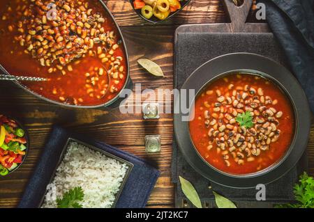 Arabic Cuisine; Middle Eastern traditional black- eyed beans in tomato sauce. Served with white rice and oriental pickles and green salad. Stock Photo