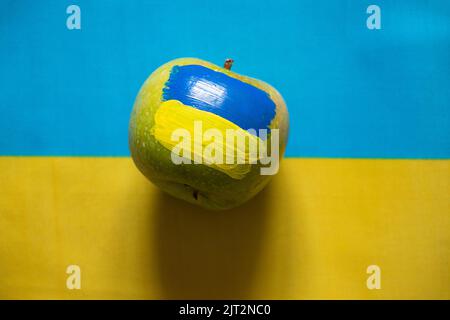 Yellow blue national flag of ukraine and green apple with ukrainian flag pattern as background stop war and peace in ukraine 2022 Stock Photo