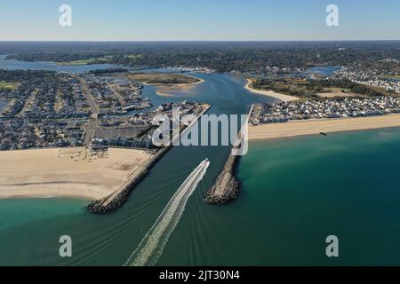 A drone shot of a ship passing through the Manasquan Inlet in New Jersey on a bright sunny day Stock Photo