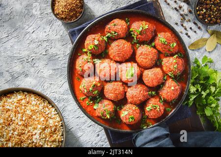 Middle Eastern traditional spiced meatballs in tomato sauce "Dawood Basha". Served with rice with vermicelli. Close up with copy space. Stock Photo