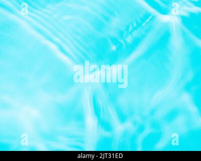 Ripple water texture on blue pool background. Shadow of water on sunlight. Mockup for product, spa or travel background. Marble blue water surface as wallpaper background Stock Photo