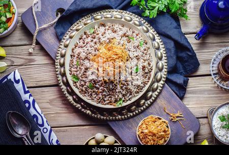 Arabic cuisine; Traditional  oriental dish 'Mujadara' or Mudardara'. It consists of cooked  black lentils, rice and crispy fried onion. Stock Photo