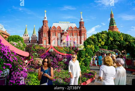 Moscow - Aug 2, 2022: Festival of flowers on Manezhnaya Square, Moscow, Russia. Historical Museum and Kremlin, tourist attractions in distance. People Stock Photo