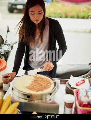 Now that looks delicious. a food vendor in Thailand preparing a tasty snack. Stock Photo