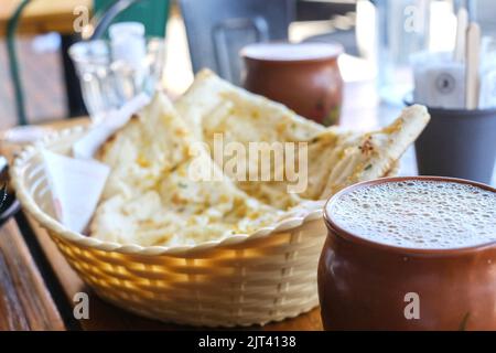 Two clay cups of masala chai and a basket of garlic naan at Chatkazz, a Mumbai-style street food restaurant in Harris Park — Sydney, Australia Stock Photo