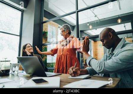 Successful businesspeople high fiving each other during a meeting in an office. Cheerful business colleagues celebrating their achievement. businesspe Stock Photo