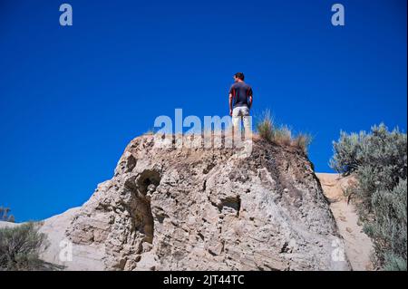 Low angle view of mature man standing on the rock Stock Photo
