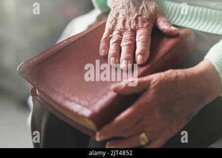 Its where you can find comfort. Closeup shot of an unrecognisable woman reading a bible. Stock Photo