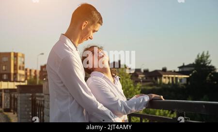 Young disabled couple in shirts looks at each other smiling Stock Photo
