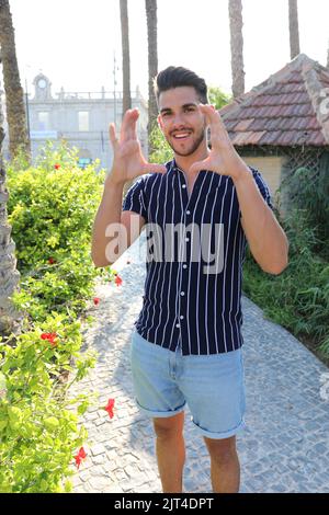 Cheerful young farmer wearing casual clothes is posing in his garden Stock Photo
