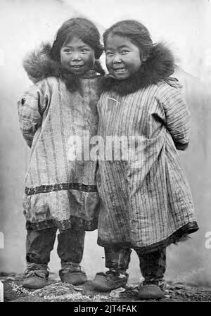 Two smiling Kauwerak Eskimo girls wearing print cotton parkas, Nome