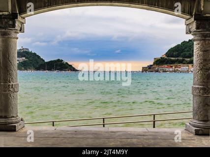 La Concha bay and beach viewed through an arch of the promenade Paseo de la Concha in San Sebastian Donostia, Basque Country, Spain Stock Photo