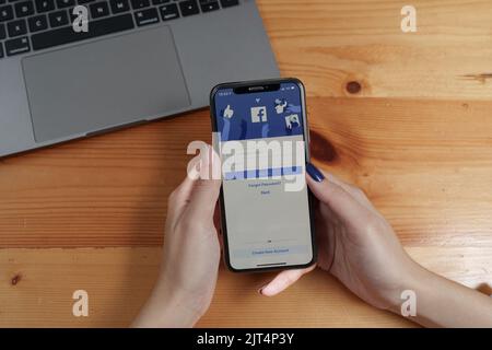CHIANGMAI, THAILAND - AUG 26, 2022 : Asian woman holds smartphone with facebook login screen. facebook from meta Stock Photo