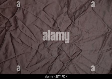 Brown shiny soft silk fabric - wavy and folding texture - brown silk fabric stock photo Stock Photo