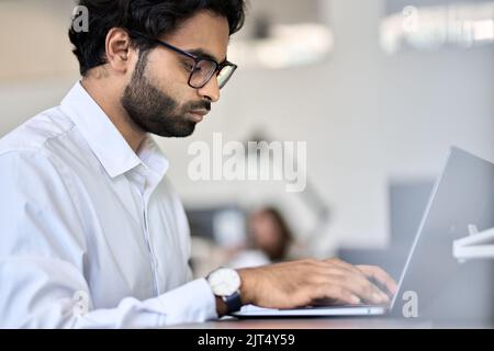 Indian business man software engineer using laptop computer working in office. Stock Photo