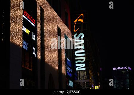 Stuttgart, Germany - December 31, 2021: Saturn electronics and technology store. christmas decorated building facade in the urban night. Stock Photo