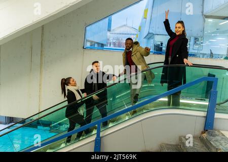 Group of multiracial busniess people are going down the escalator Stock Photo