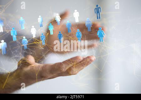 A businessman holding a floating digital render of people icons, a global network concept Stock Photo