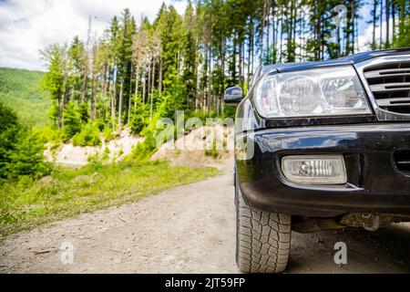 Off-road travel on mountain road. Travel concept with big car . Closeup photo of offroad wheel. Closeup of car wheel on steppe terrain. Off-road on Stock Photo