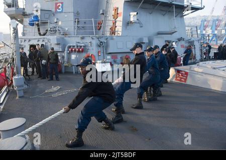 U.S. Sailors aboard the guided missile destroyer USS Stout (DDG 55) heave mooring lines as the ship pulls into port in Haifa, Israel, Jan. 19, 2014, for a scheduled port visit 140119 Stock Photo