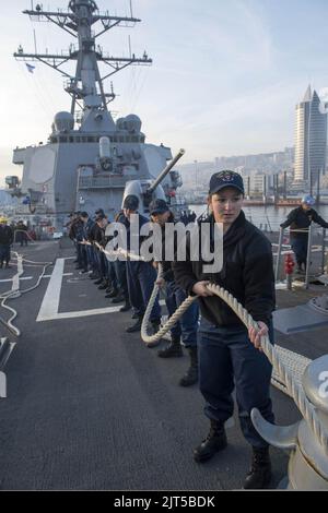 U.S. Sailors aboard the guided missile destroyer USS Stout (DDG 55) heave mooring lines as the ship pulls into port in Haifa, Israel, Jan. 19, 2014, for a scheduled port visit 140119 Stock Photo