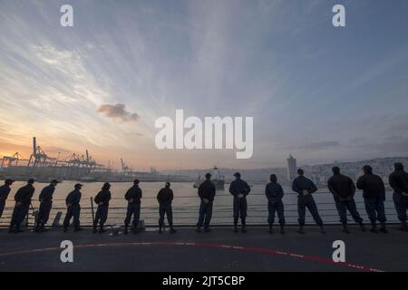 U.S. Sailors man the rails aboard the guided missile destroyer USS Stout (DDG 55) as the ship pulls into port in Haifa, Israel, Jan. 19, 2014, for a scheduled port visit 140119 Stock Photo