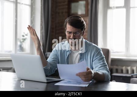 Stressed angry business leader man reading report, getting bad news Stock Photo