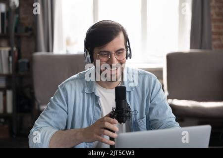 Happy engaged radio host, blogger man in wireless headphones Stock Photo