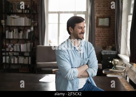 Happy dreamy millennial business man looking at window away Stock Photo