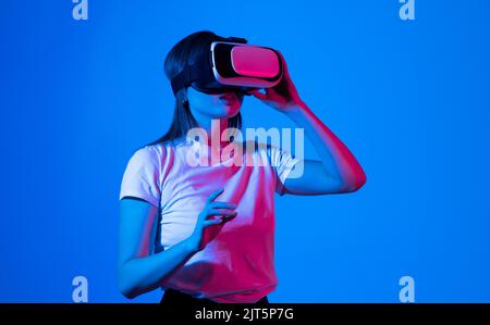 Creative engineer working with virtual reality, young woman testing VR glasses or goggles sitting in the studio room and working with engineering Stock Photo