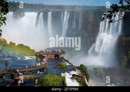 Tourists exploring the Brazilian side of Iguazu Falls, on the border of Brazil and Argentina.