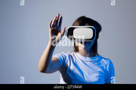 Creative engineer working with virtual reality, young woman testing VR glasses or goggles sitting in the studio room and working with engineering Stock Photo