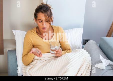 Concept of suffering from terrible pain. Beautiful, sad, upset, unhappy, troubled, weak woman with blonde hair, wearing casual clothes is sitting on a Stock Photo