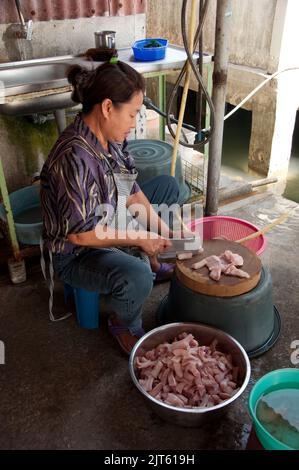 Woman preparing fish, Restaurant, Tan Jetty, George Town, Penang, Malaysia, Asia.  Tan Jetty is one of the oldest settlements on Penang and most of th Stock Photo