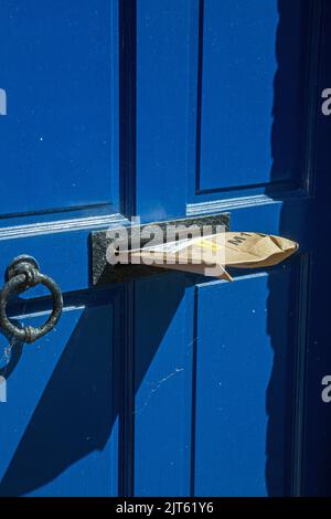 Aldeburgh, Suffolk, England, June 26th 2022, a package stuffed into a letterbox and left insecure Stock Photo