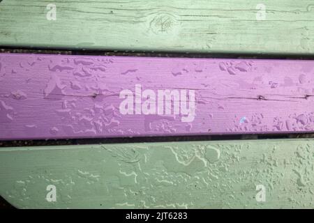 Raindrops on green and purple painted planks of wood Stock Photo