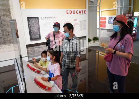 (220828) -- BEIJING, Aug. 28, 2022 (Xinhua) -- Kids try drum-striking while visiting an exhibition at the ground floor of Gulou, a historic drum tower, in Beijing, capital of China, Aug. 28, 2022. An exhibition has recently been in trial operation at Gulou of Beijing, which explains the ancient timekeeping function, architectural features, folk culture in surrounding areas and its relationship with Beijing's central axis through an immersive and interactive experience. (Xinhua/Chen Zhonghao) Stock Photo