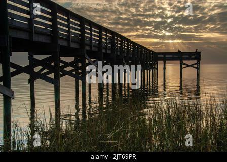 Silhouette of a wood pier over a lake at dawn Stock Photo