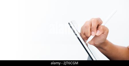 Hand holding white electronic pen or pencil, writing or drawing on digital tablet screen isolated on white background with copy space, side view. Work Stock Photo