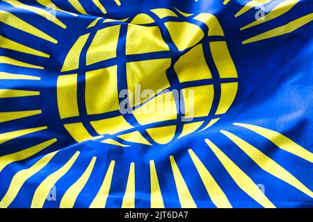 A closeup shot of deep tones of the ruffled flag of Commonwealth Symbol Visual Identity Stock Photo