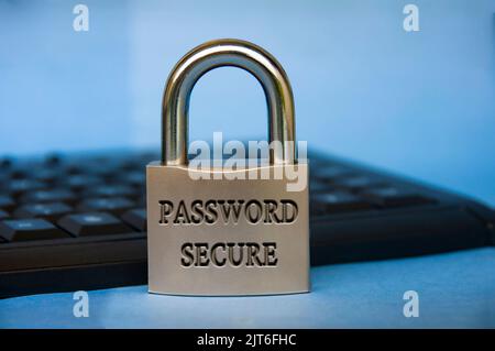 Password secure text engraved on padlock with blurred keyboard background. Password security concept. Stock Photo