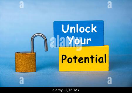 Unlock your potential text wooden blocks with padlock on blue background. Motivational concept. Stock Photo