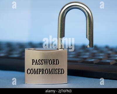 Password compromised text engraved on padlock with blurred keyboard background. Password security concept. Stock Photo